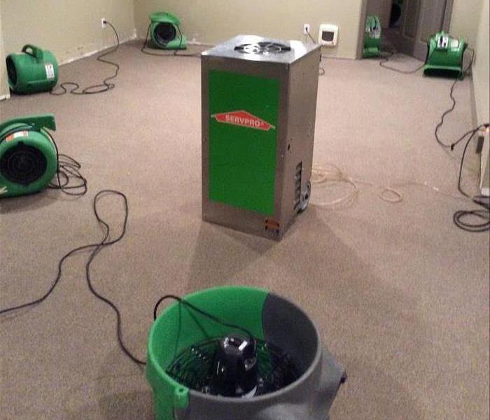 dehumidifier and air movers in water damaged room with carpet
